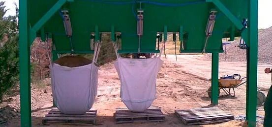 Una estructura verde con tres bolsas colgando de ella.