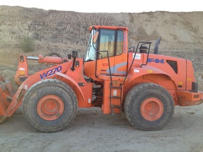 Una cargadora de ruedas naranja con las letras w220 en el lateral