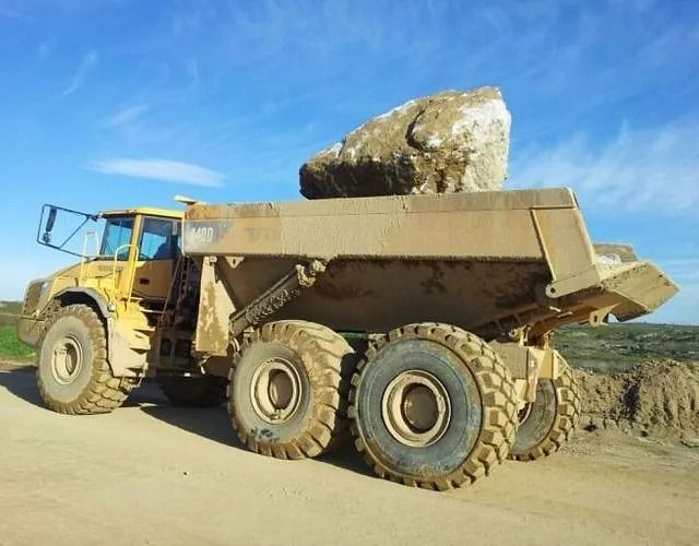 Un camión volquete con una gran roca encima