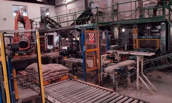 Un almacén lleno de mucha maquinaria y una cinta transportadora.