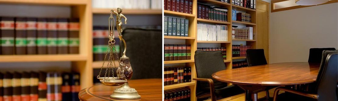 Despacho de abogados con estanterías, mesa redonda y una estatua de la Dama de la Justicia.