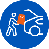 Une personne entrain de mettre ses courses dans le coffre de sa voiture.
