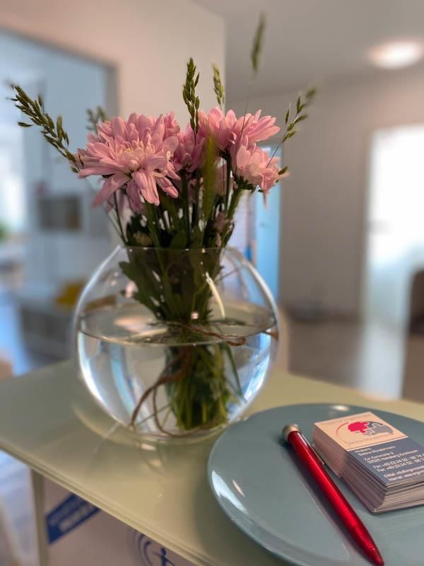 Eine Vase mit rosa Blumen steht auf einem Tisch