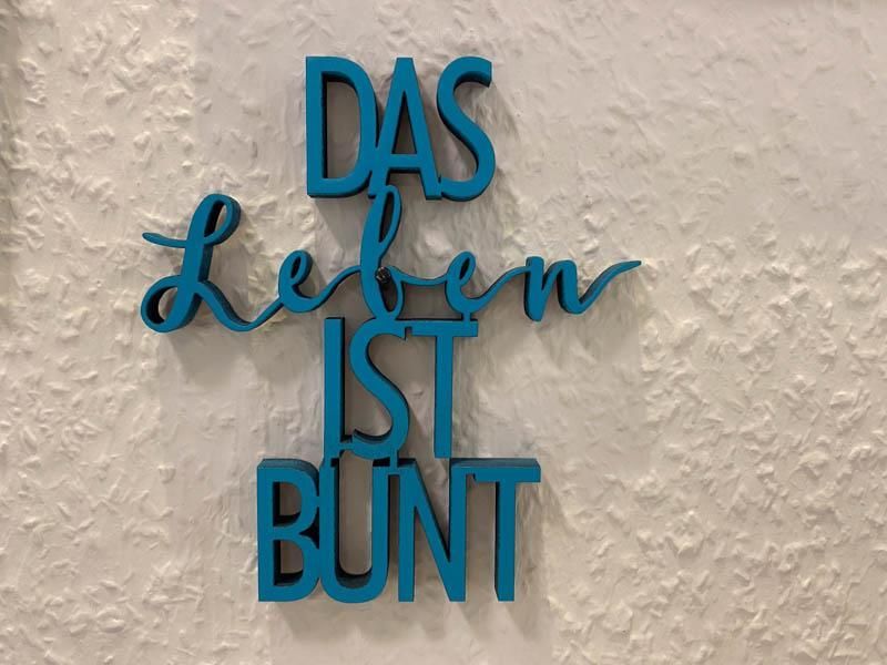 A sign on a wall that says das leben ist bunt