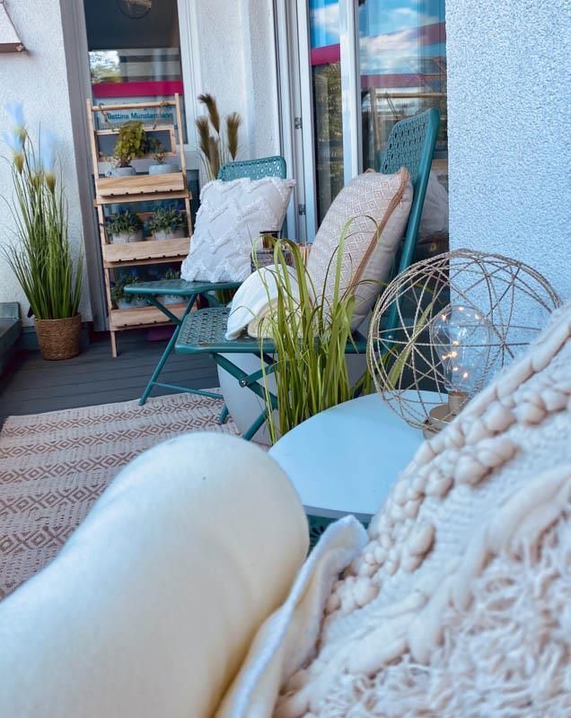 Ein Balkon mit einem Stuhl, einem Tisch und einer Pflanze