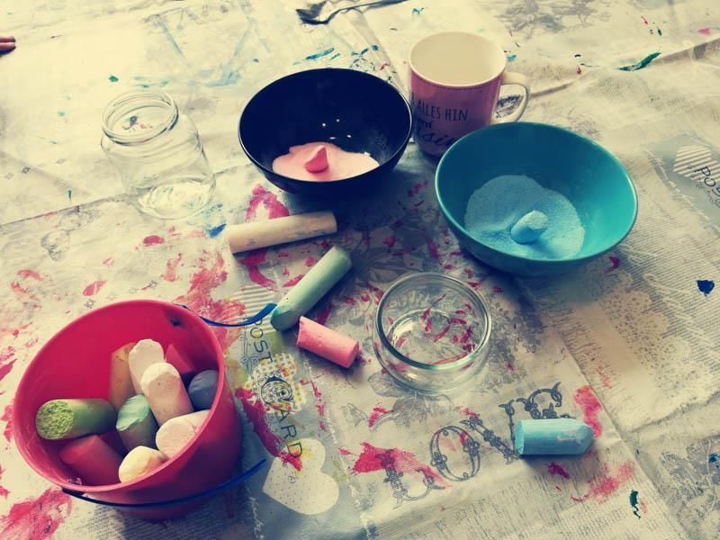 Ein Tisch mit Schüsseln voller Kreide und einer Tasse mit dem Wort Liebe darauf