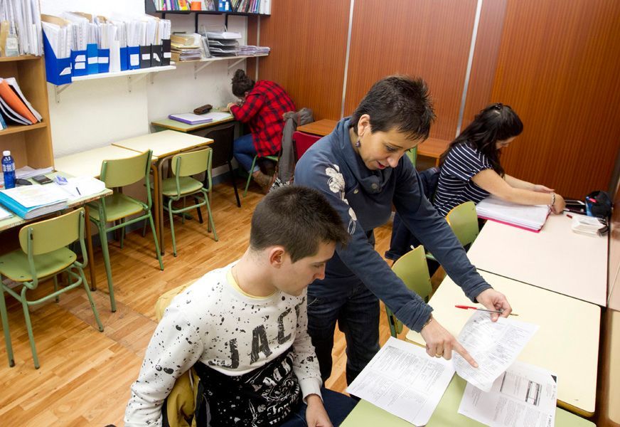 Un hombre con una camisa jac señala un trozo de papel.