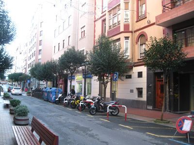 Una fila de motocicletas están estacionadas al costado de una calle