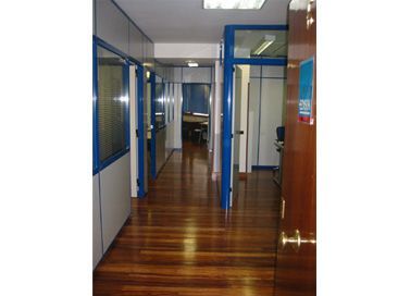 Un pasillo con suelos de madera y puertas azules.