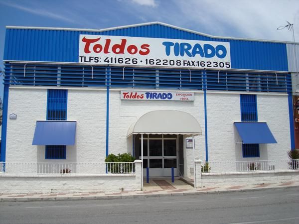 Un edificio con un cartel que dice toldos tirado