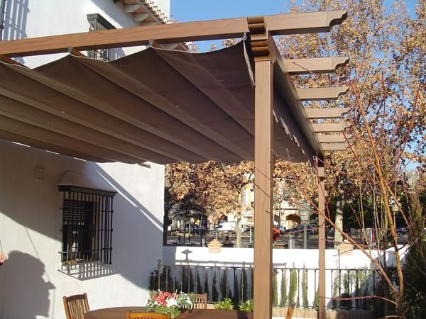 Una pérgola con una mesa y sillas debajo.