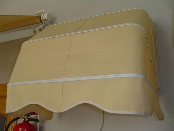 Un toldo beige está colgado en una pared al lado de un extintor de incendios.