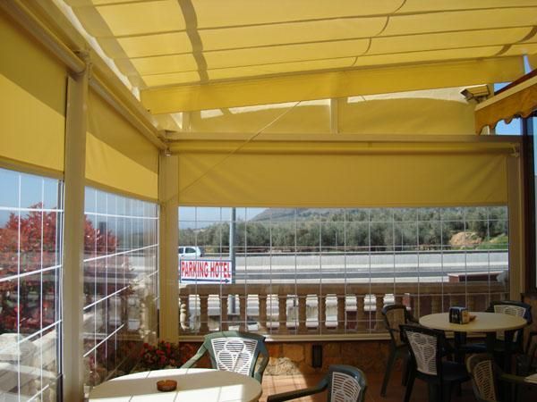 Un restaurante con mesas y sillas bajo un toldo amarillo.