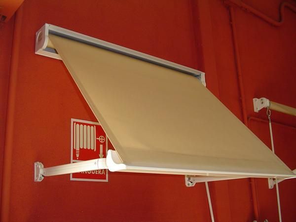 Un toldo blanco cuelga de una pared roja.