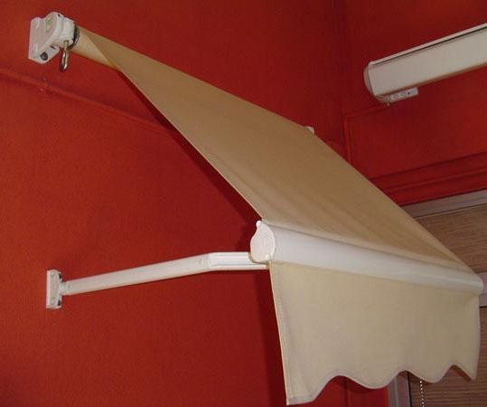 Un toldo blanco cuelga de una pared roja.