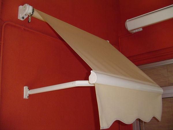 Un toldo blanco está fijado a una pared roja.
