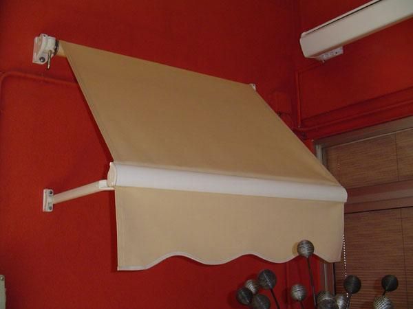 Un toldo color canela cuelga de una pared roja.