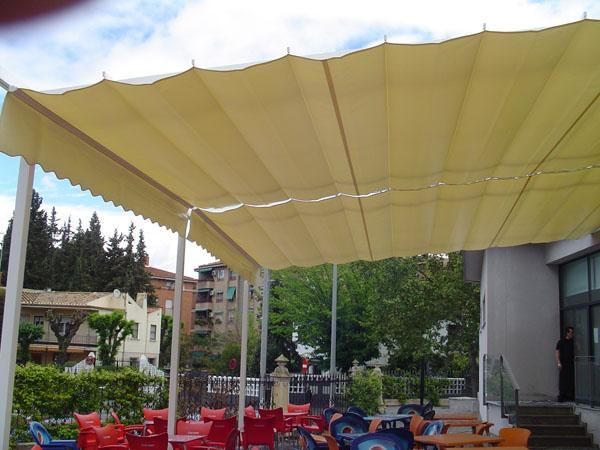 Un restaurante con mesas y sillas bajo un toldo.