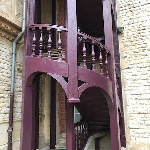 Un escalier extérieur en colimaçon en bois peint