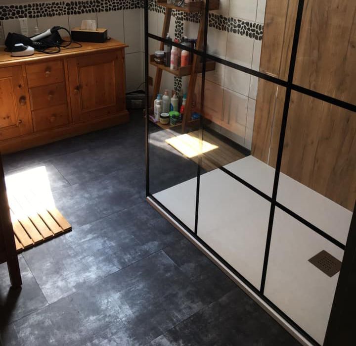 Un salle de douche avec un revêtement de sol en béton ciré