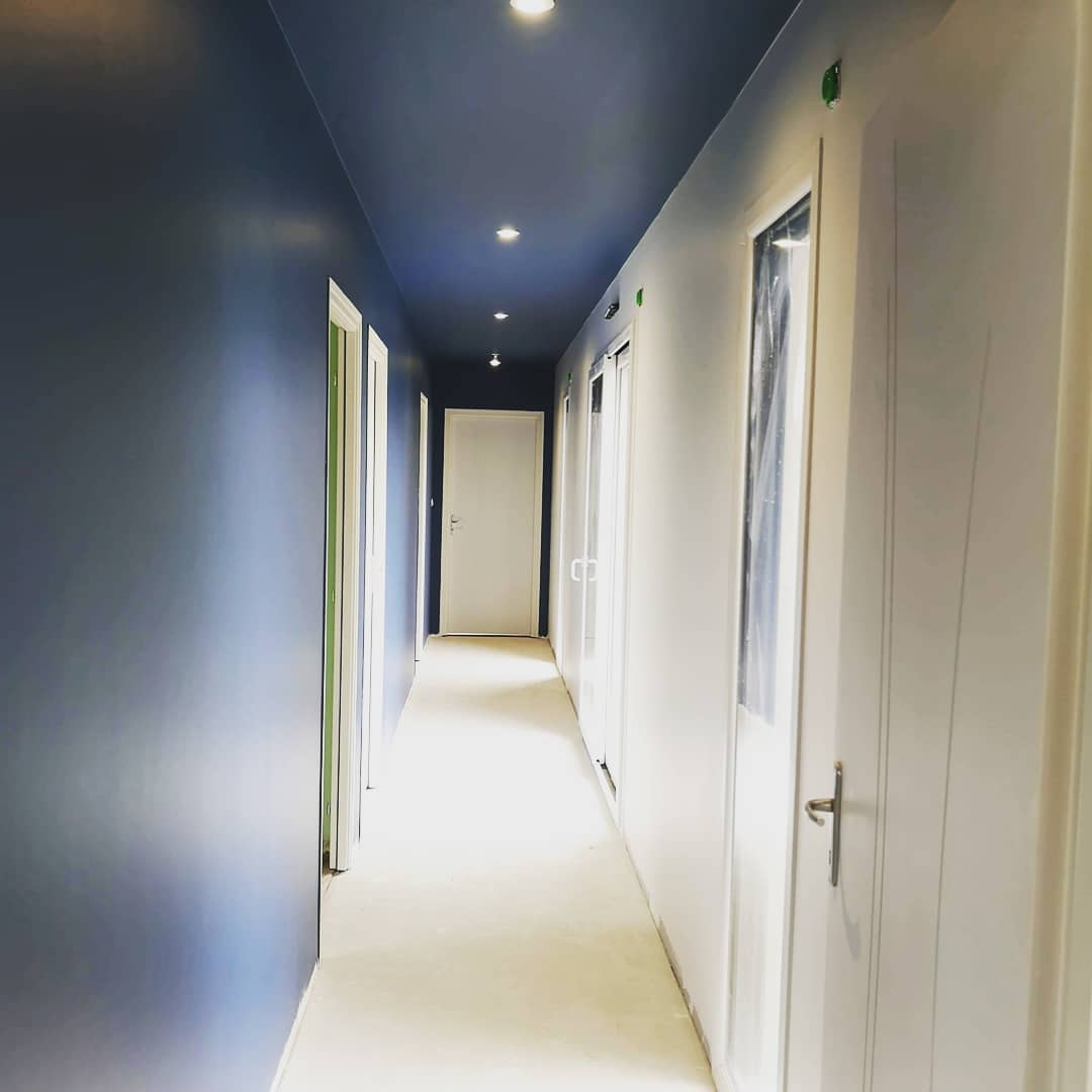 Couloir de maison avec un pan de mur et le plafond bleu nuit