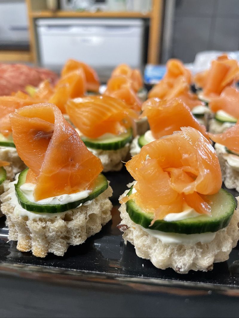 Un gros plan d'un plateau d'amuse-gueules au saumon fumé et au concombre.