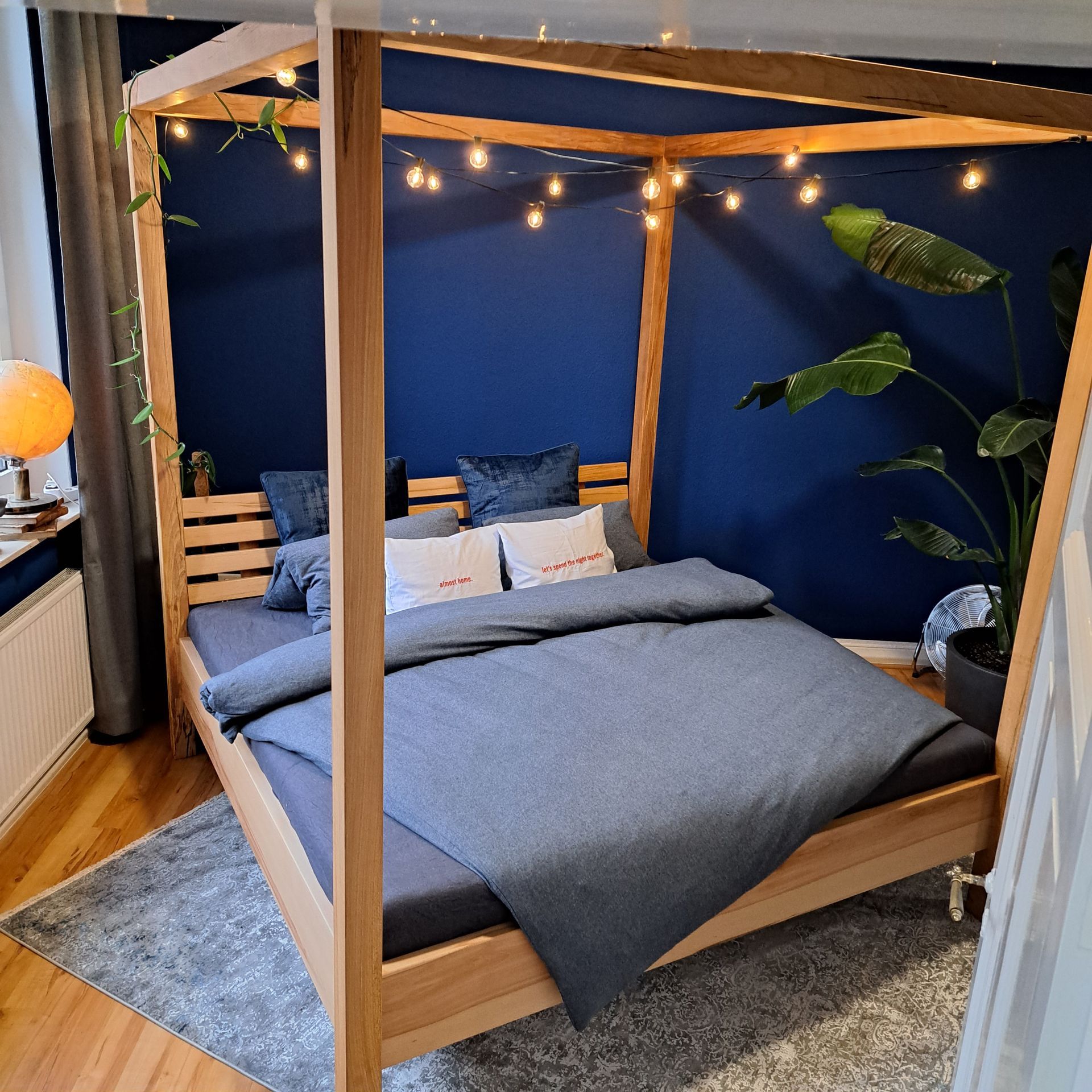 Himmelbett mit Bettwäsche und Lichterkette als Dekoration