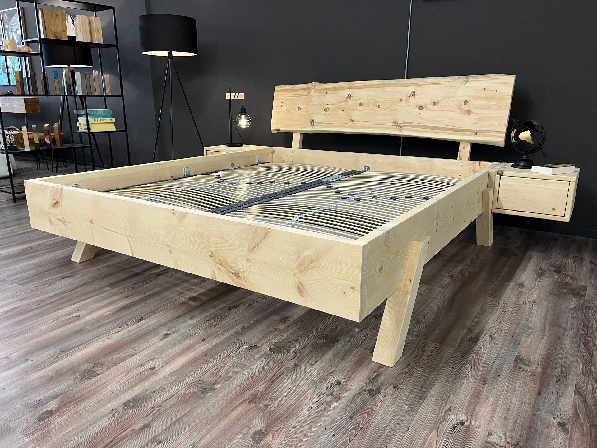 In einem Zimmer steht ein Holzbett auf einem Holzboden.