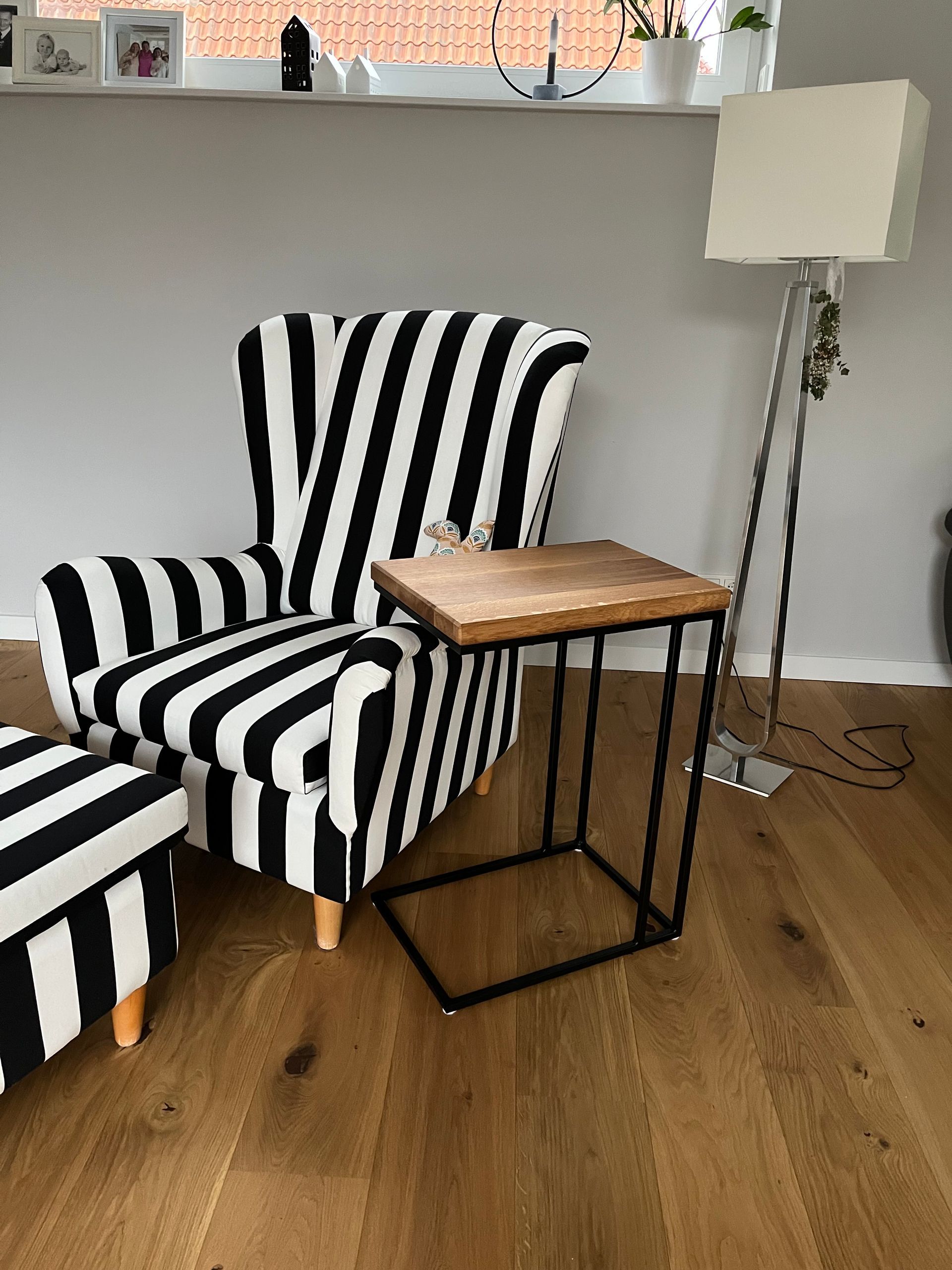 Schwarzweißer Ohrensessel mit Holzabstelltisch