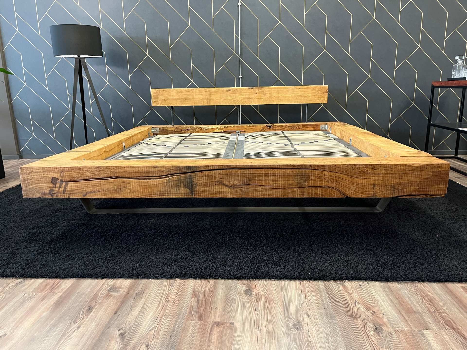Rustikales Bettgestell aus Naturholz mit charakteristischer Baumkante am Kopfteil