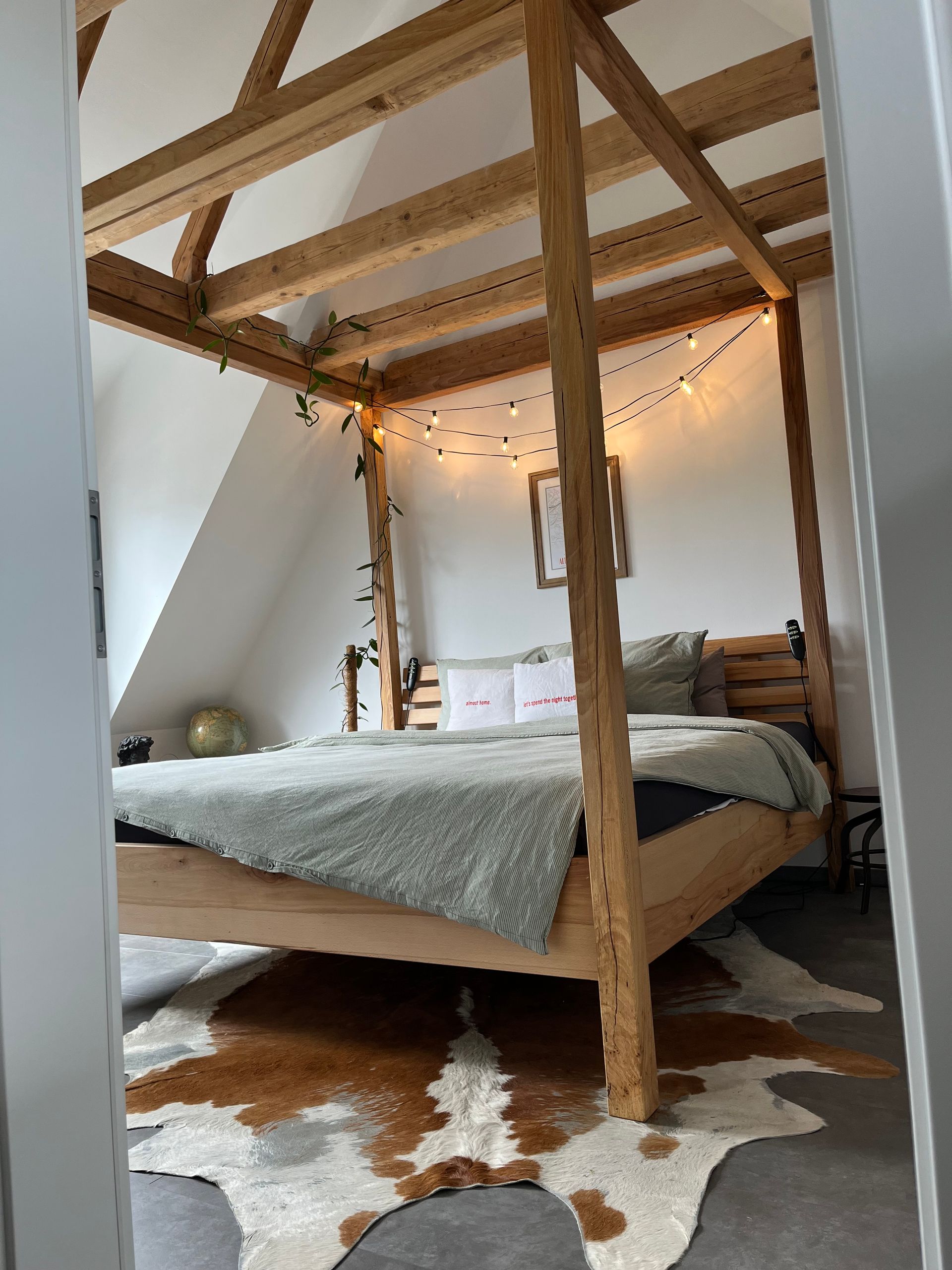 Himmelbett mit Bettwäsche und Lichterkette als Dekoration