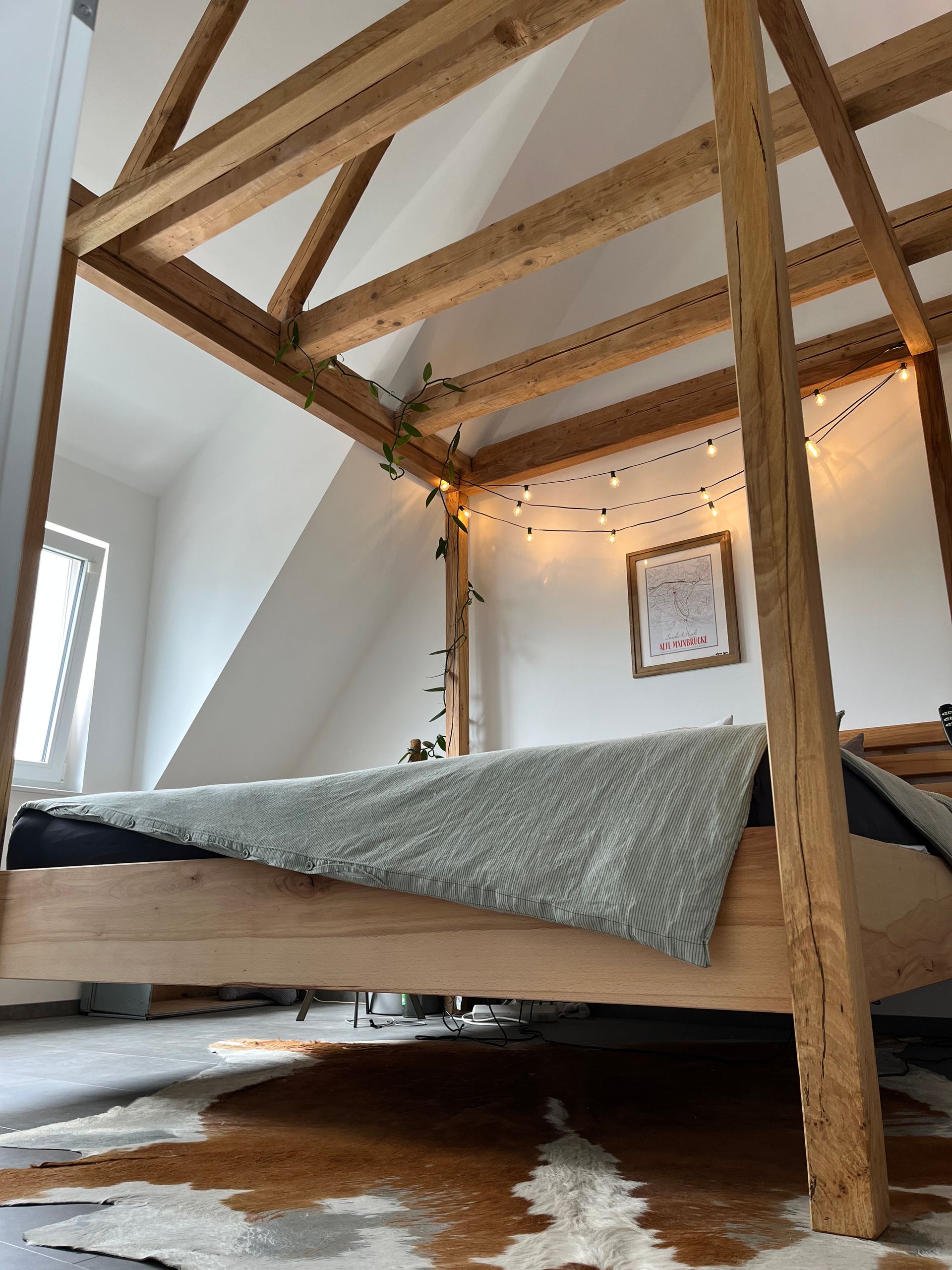 Himmelbett mit Bettwäsche und Lichterkette als Dekoration