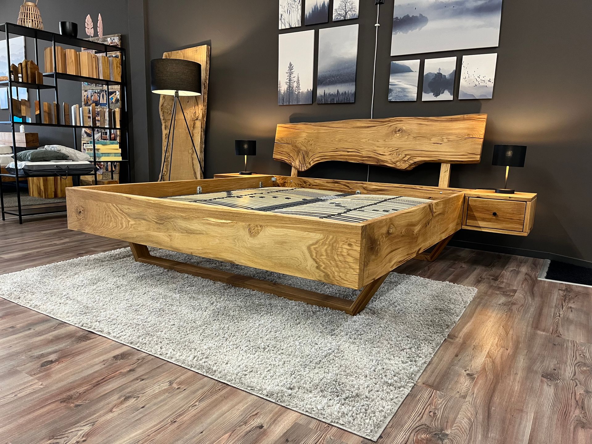 In einem Schlafzimmer steht ein Holzbett auf einem Teppich.