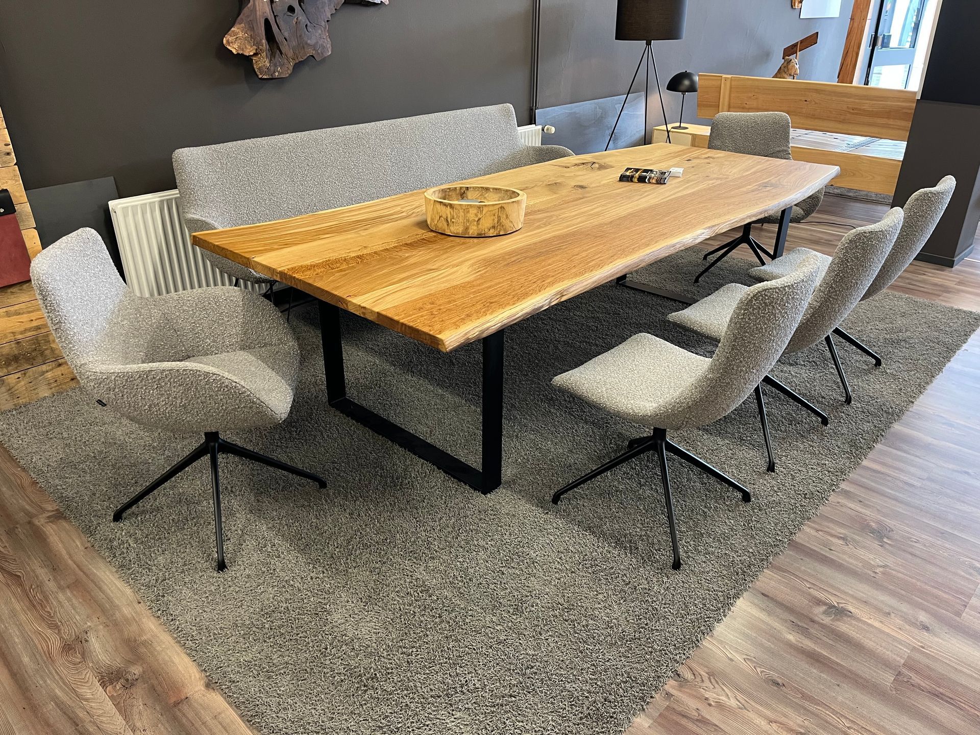 Ein Wohnzimmer mit einem langen handgefertigten Naturholz-Epoxidharztisch und blau gepolsterten Stühlen