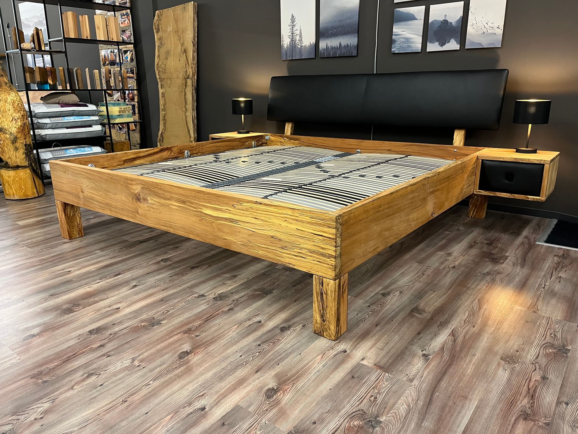 In einem Zimmer steht ein Holzbett auf einem Holzboden.