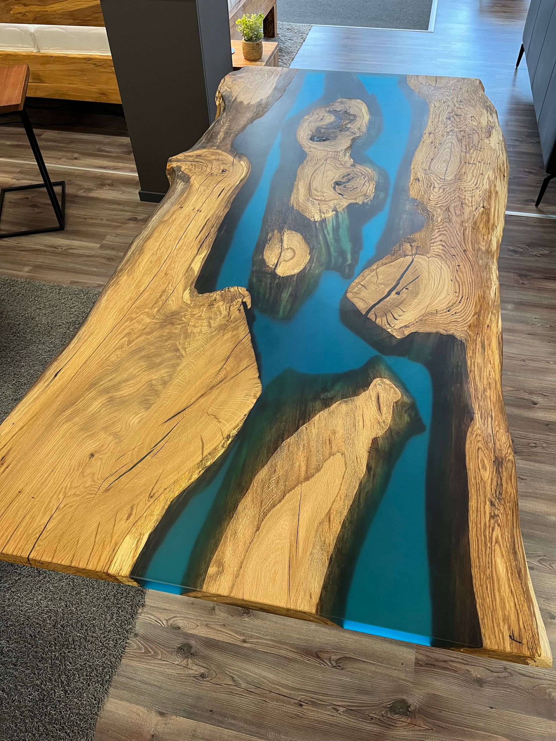 Holztisch mit natürlicher Kante und türkisfarbenem Epoxidharzfluss.