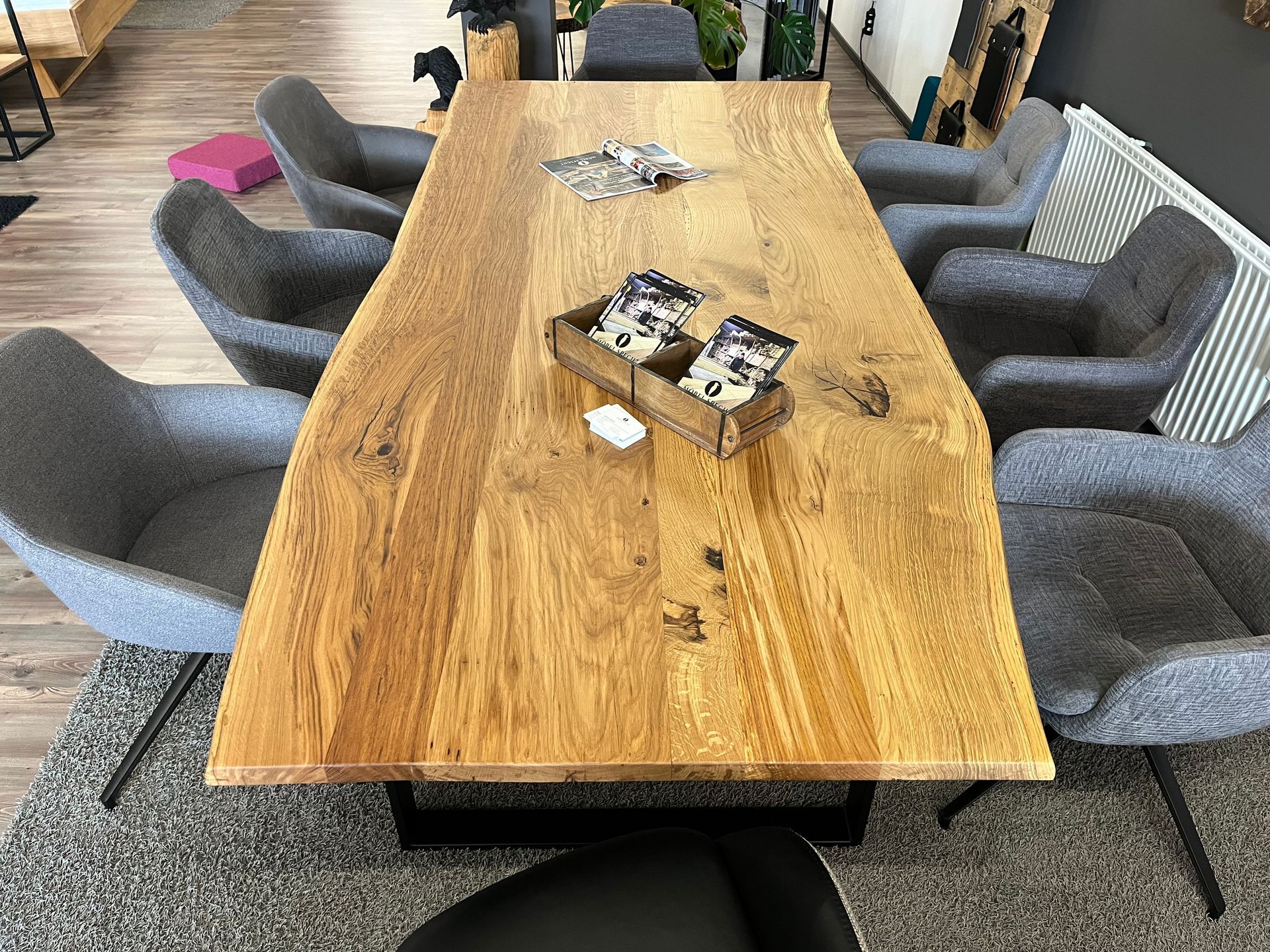 Ein langer Holztisch mit Stühlen drumherum in einem Wohnzimmer.