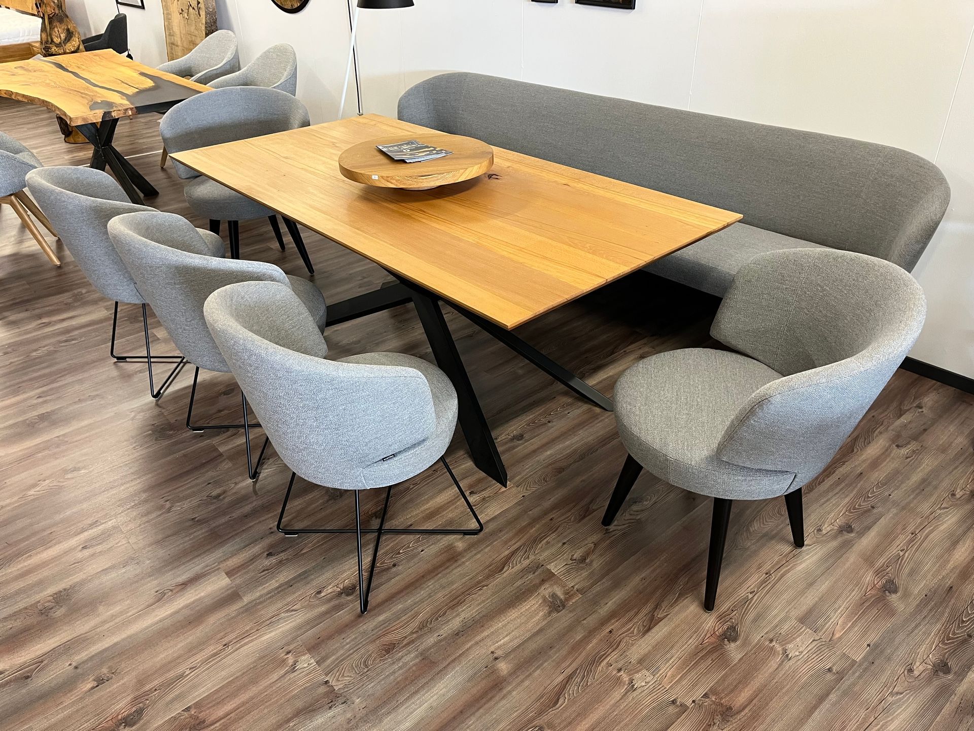 Essgruppe bestehend aus Holztisch, grauer Bank und passenden Stühlen.