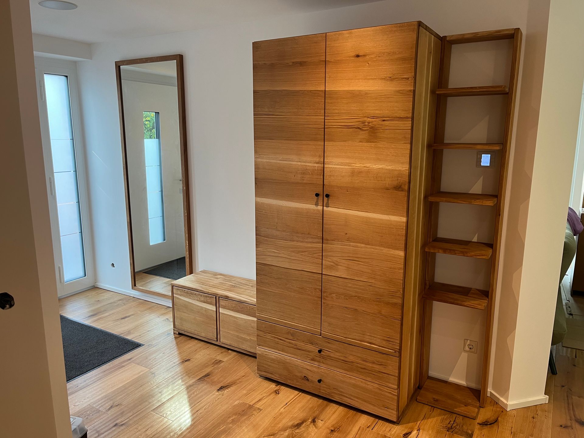 Kleiderschrank mit Holzfronten und rechts angesetztem Regal