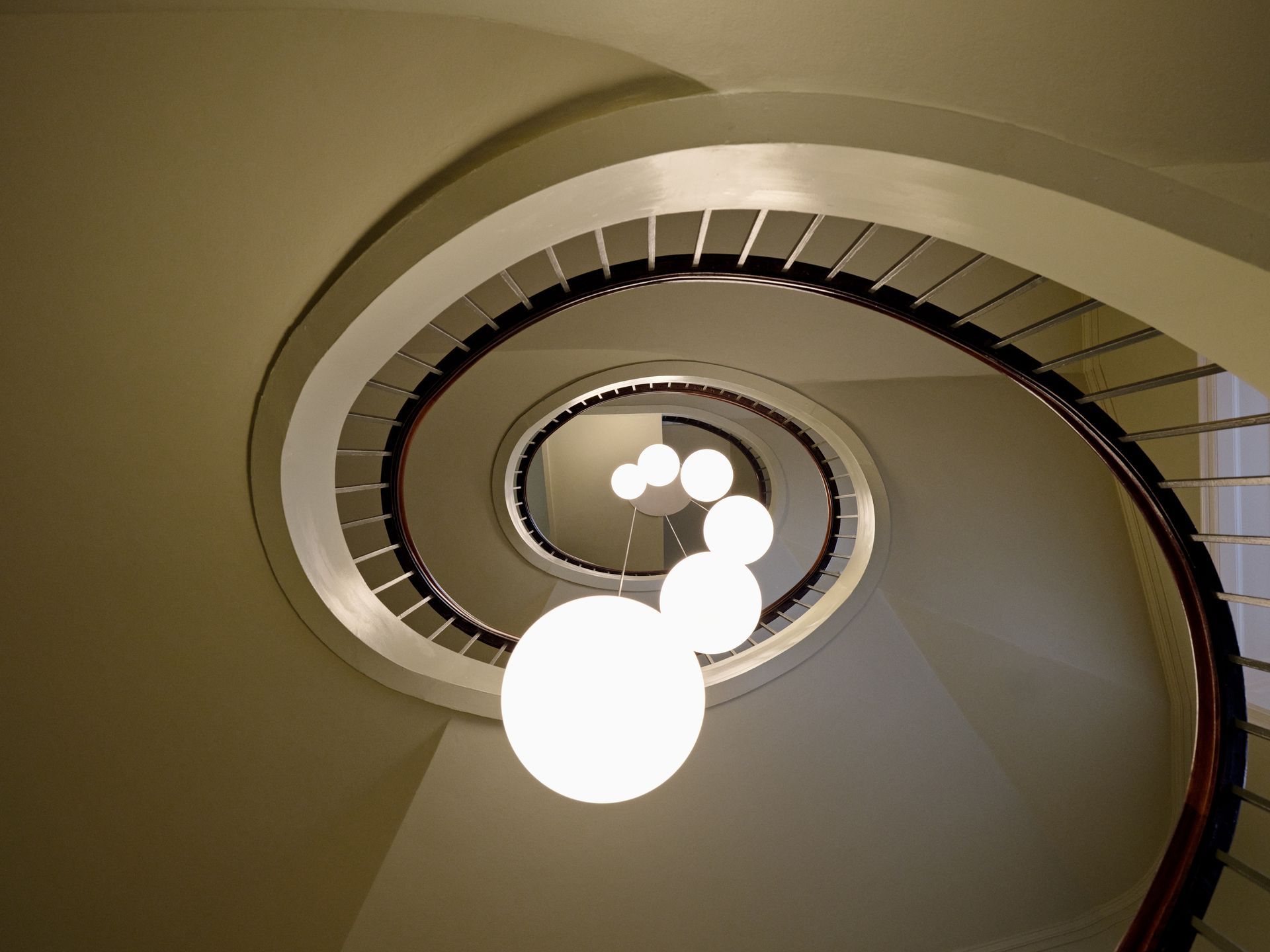 Spiral staircase with hanging spherical lights.