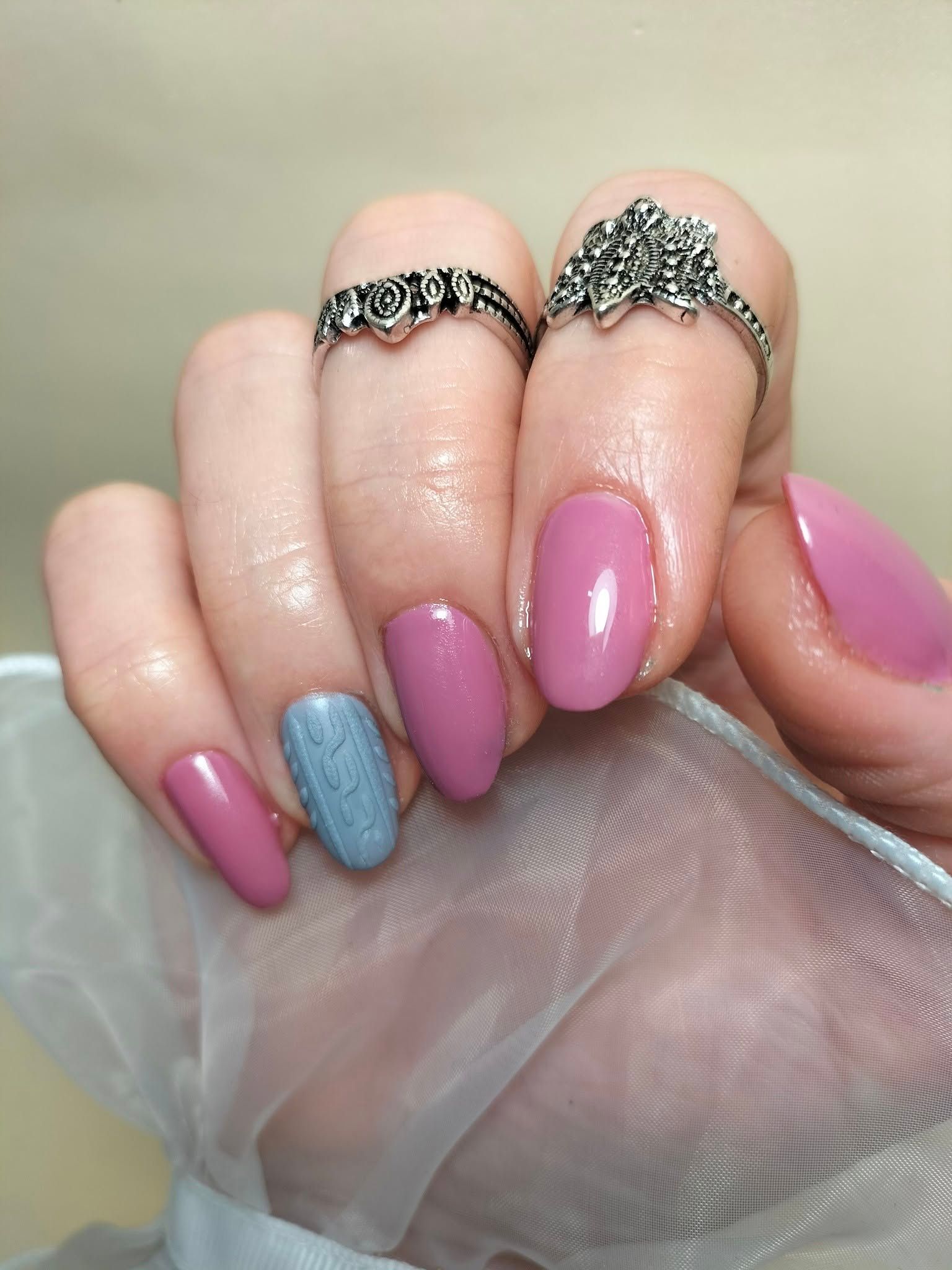 Un primer plano de las uñas de una mujer con anillos en ellas.