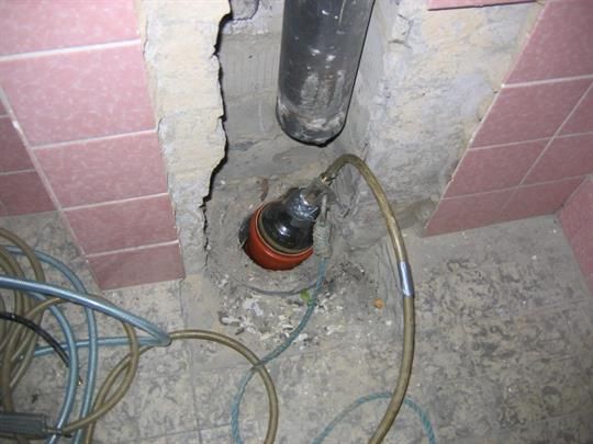 Ein Schlauch ist an ein Rohr in einem Badezimmer angeschlossen