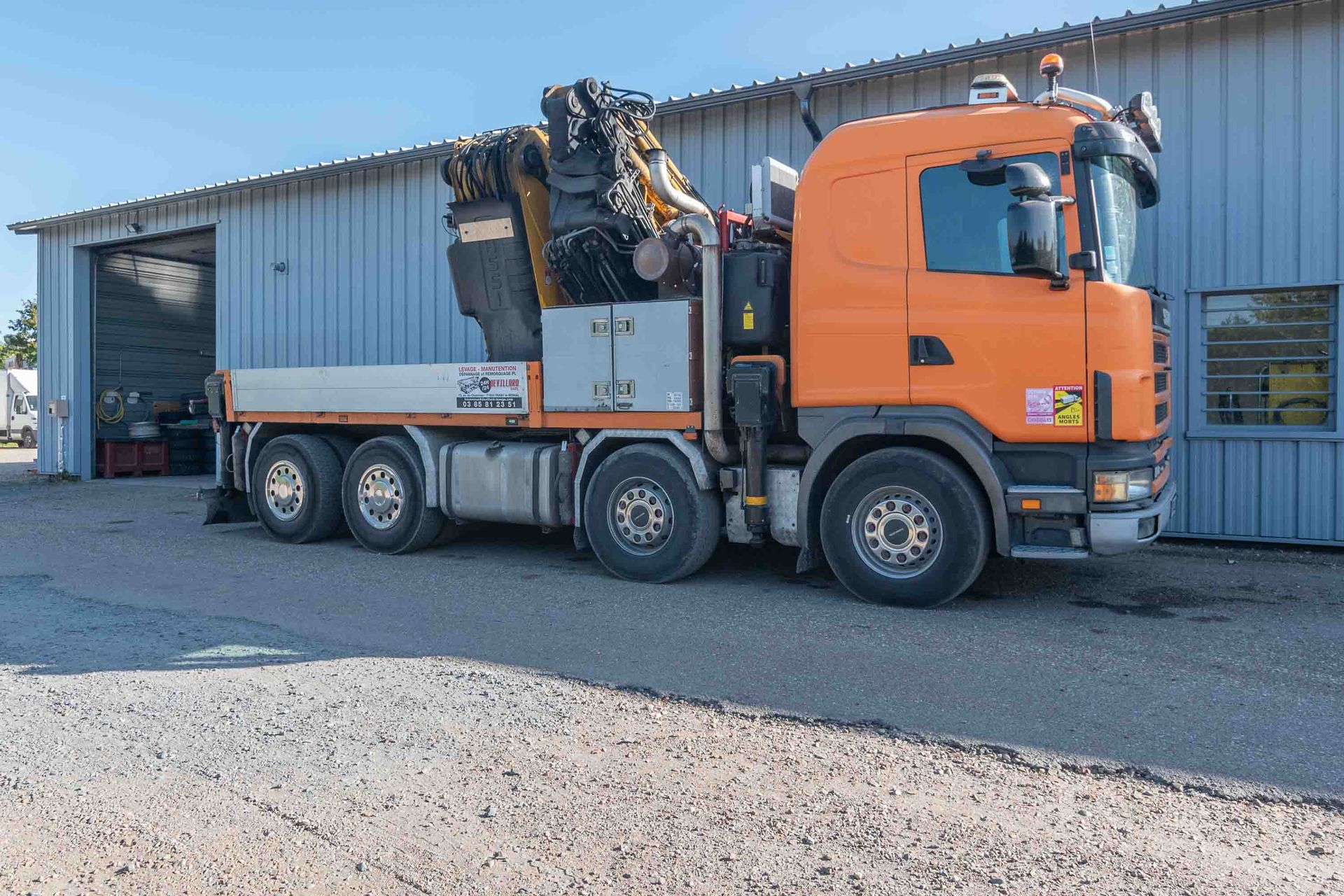 Camion orange avec gros engin de levage