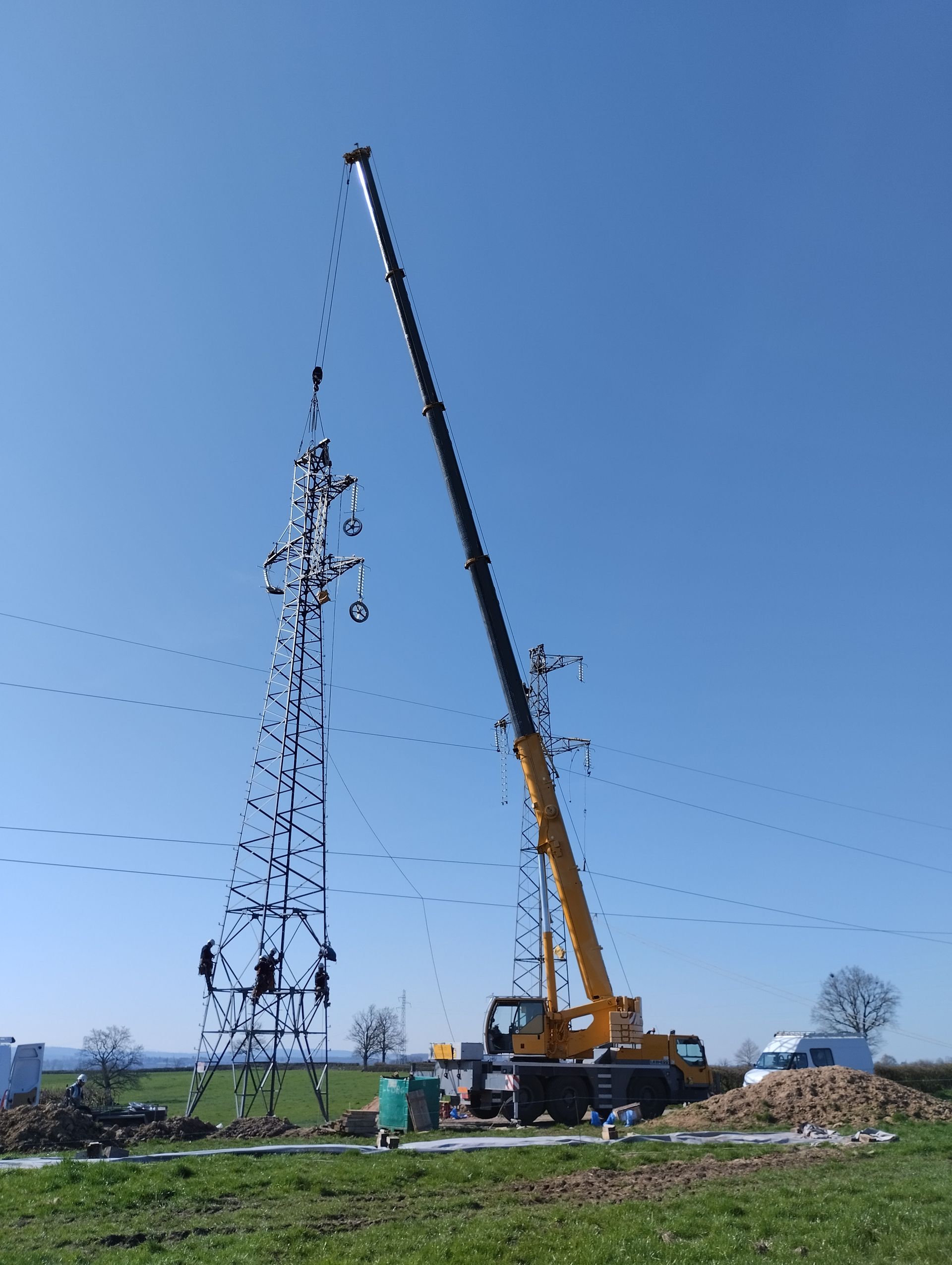 Pylône électrique dressé par un bras de levage