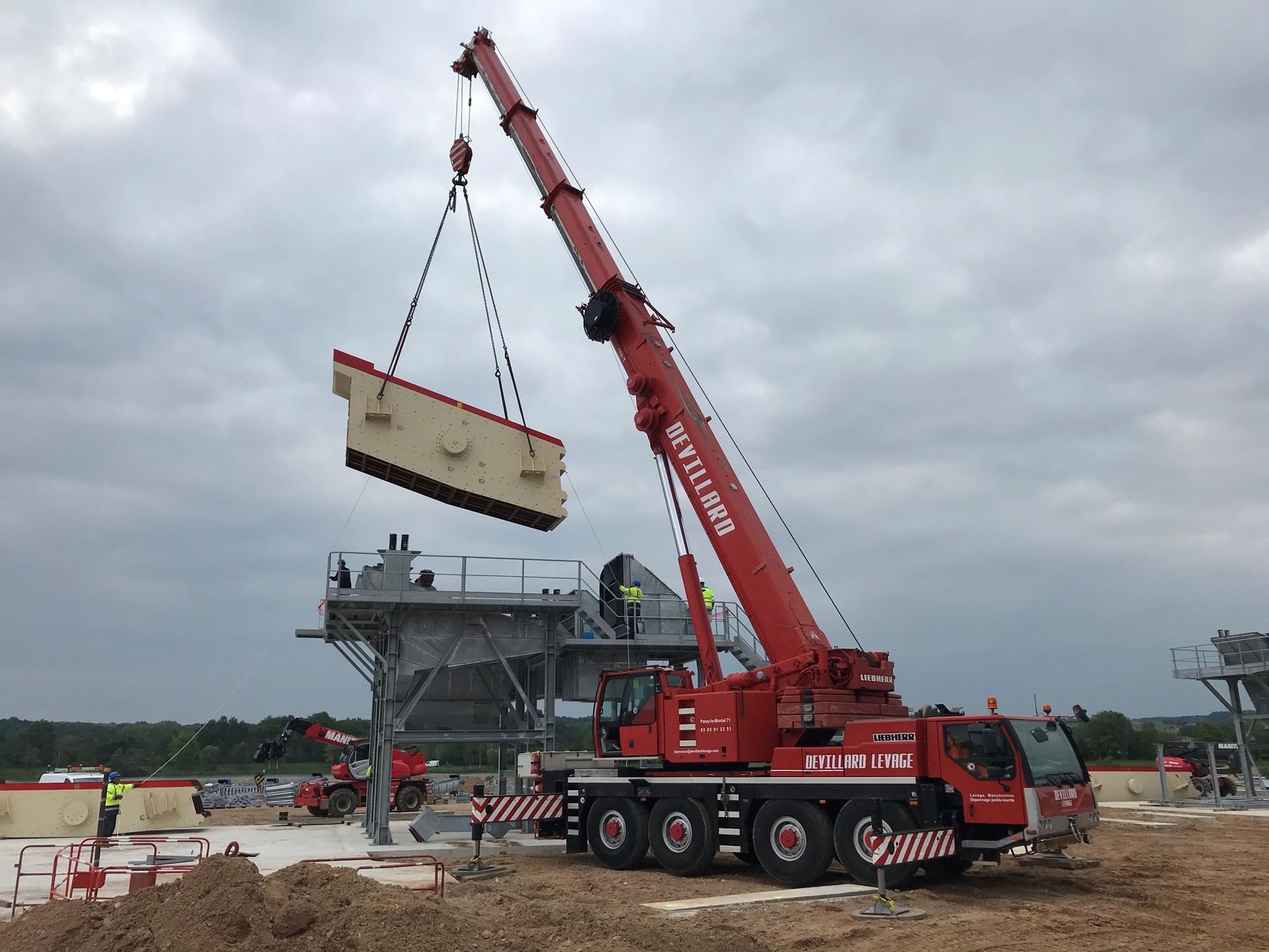 Bras de levage soulevant une pièce industrielle