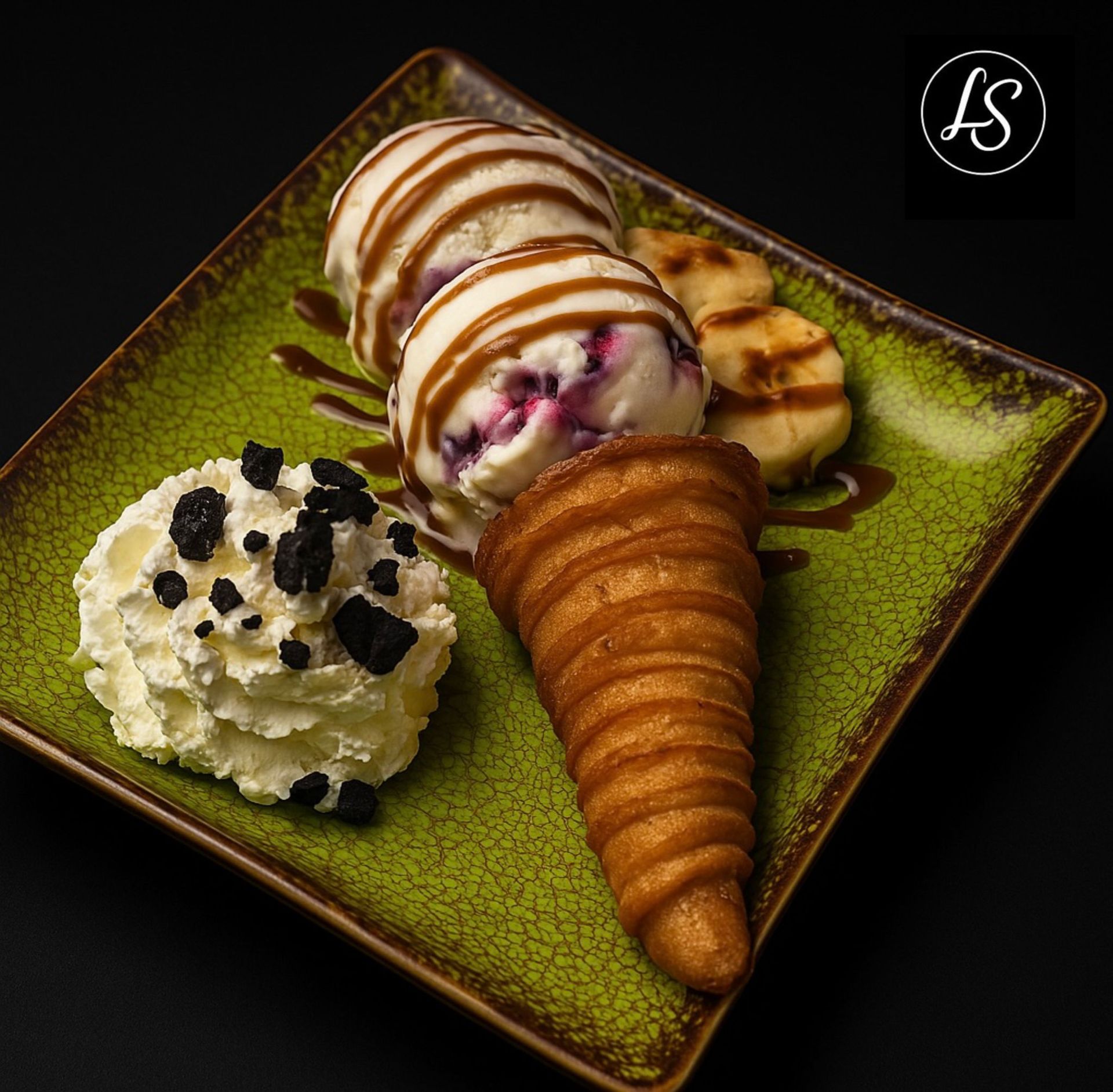 Un plato verde cubierto con helado, crema batida y plátanos.