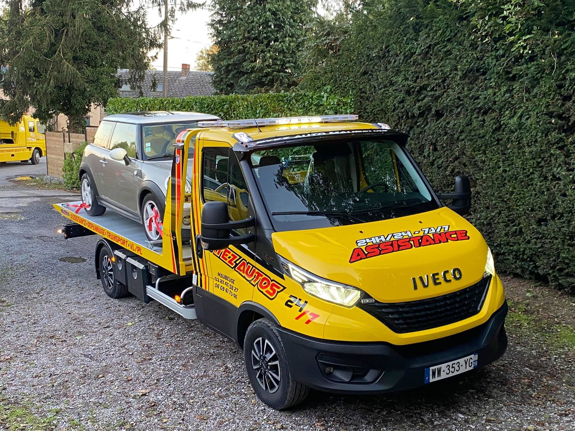 Un camion qui remorque une petite voiture grise
