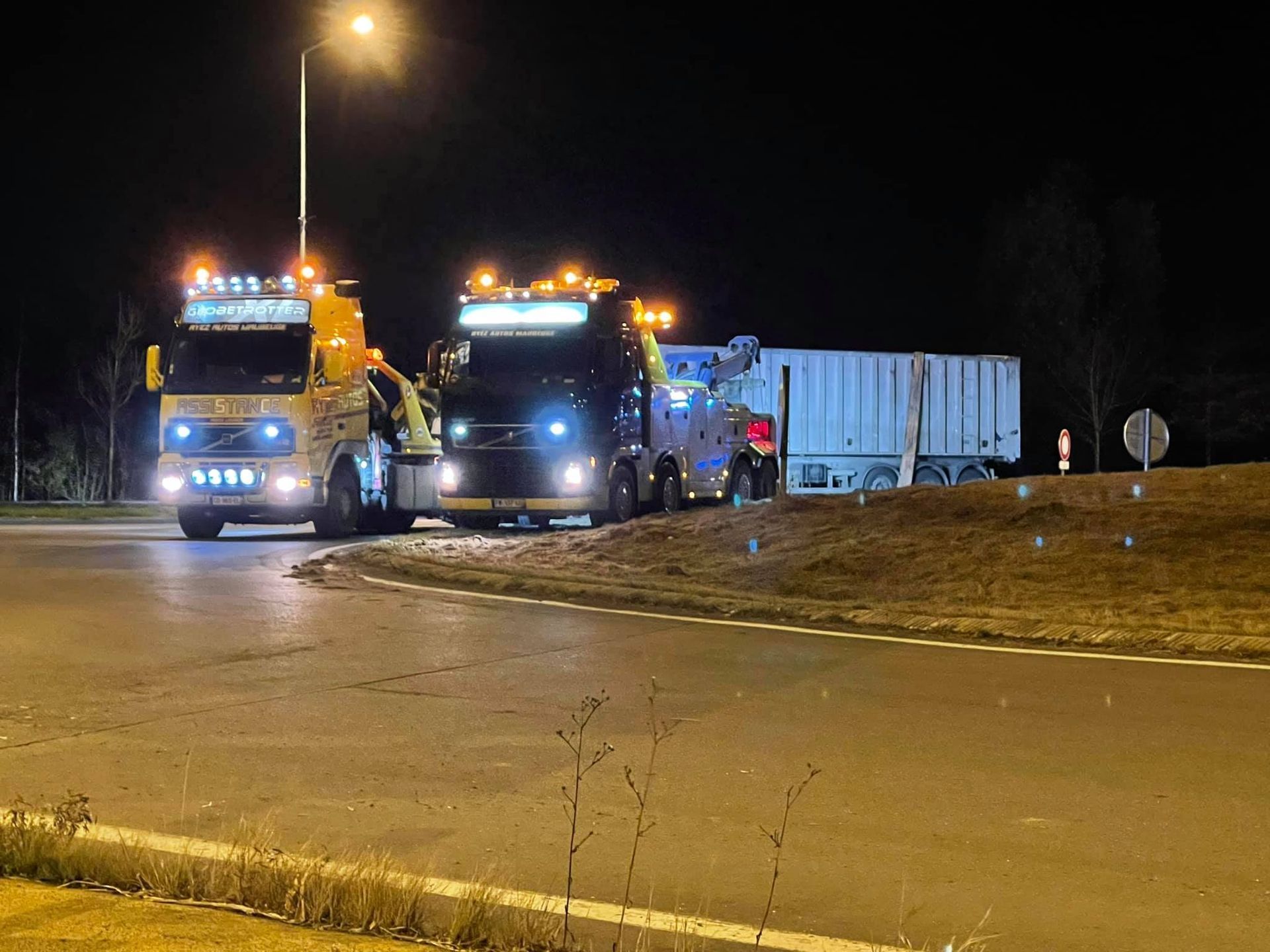 Un remorquage de camion de nuit sur un rond-point