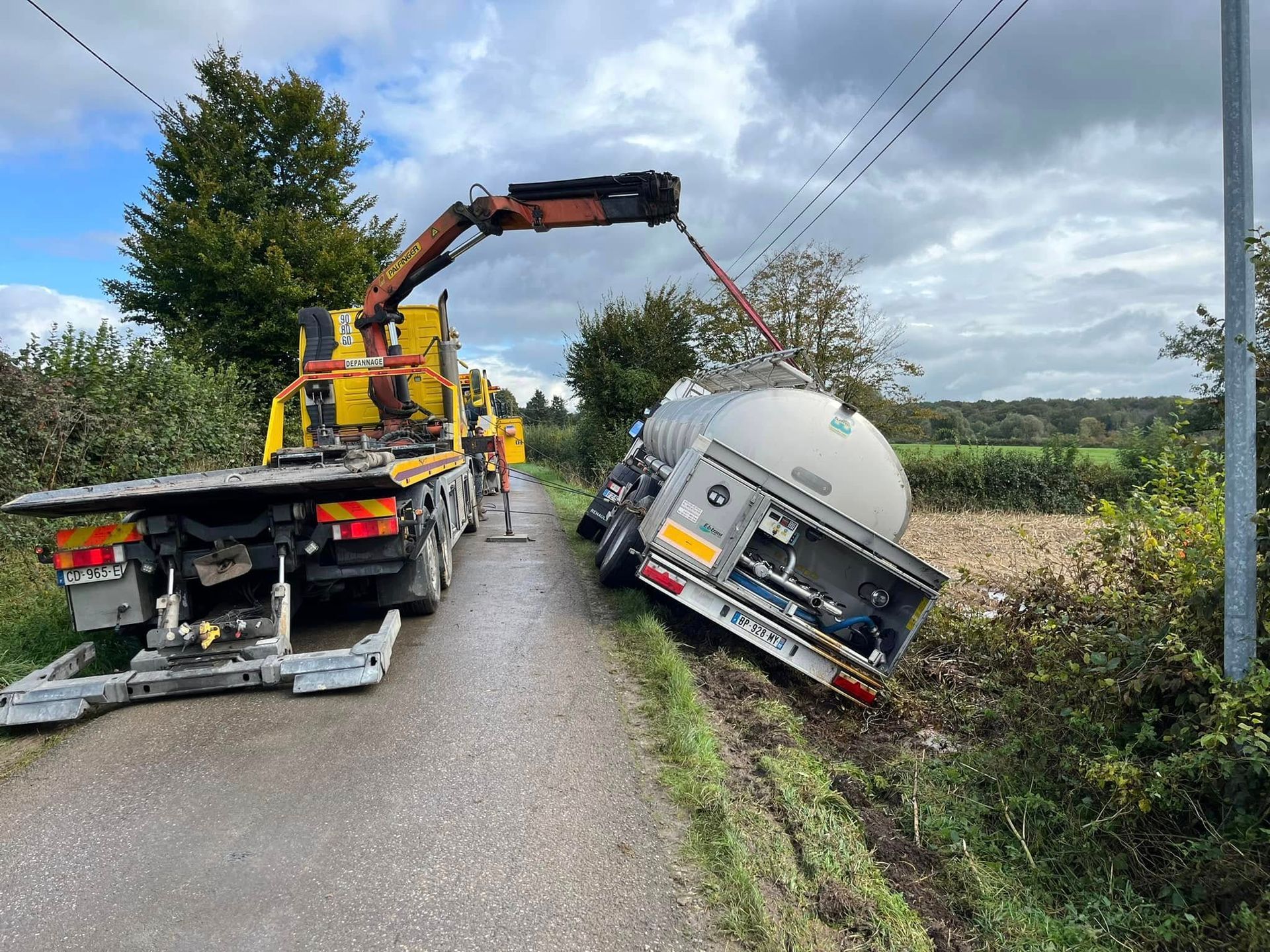 Un camion-citerne qui se fait remorquer par une dépanneuse