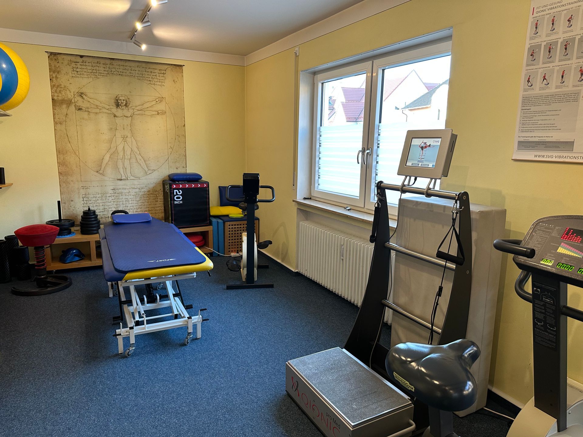 Behandlungsraum mit Therapieliege und Trainingsgeräten